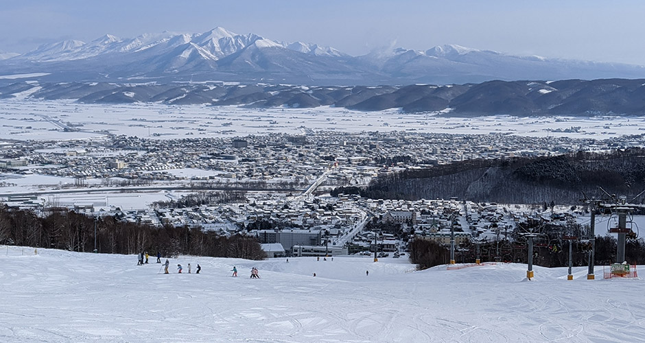 The village of Kitanomine with Furano city behind and the Tokachidake mountains in the background. Photo: Scout