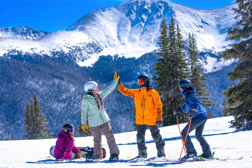 Friends skiing powder together at Winter Park